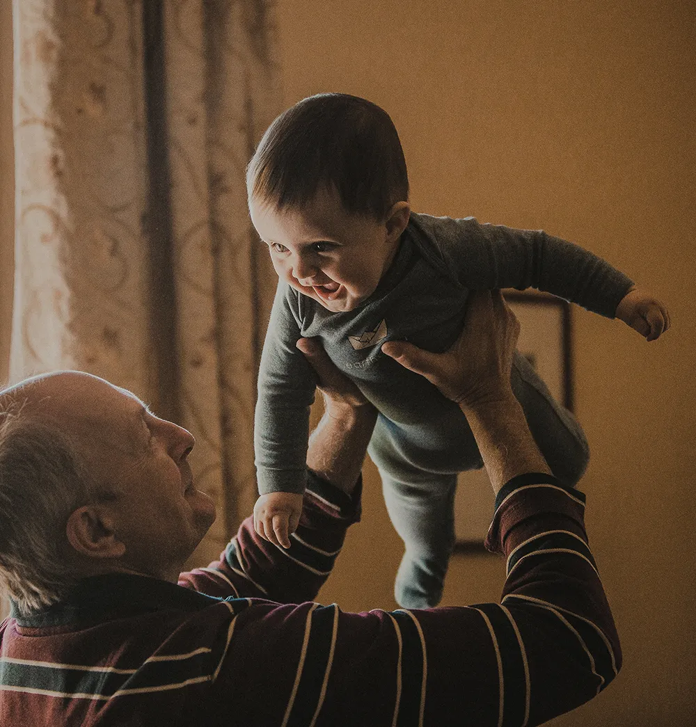 Grandfather holding up baby grandson
